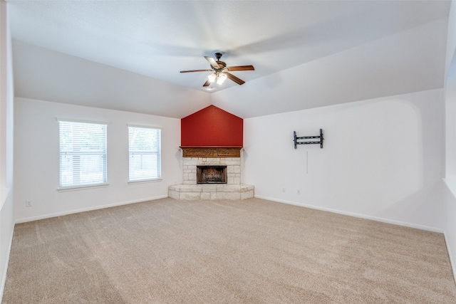 unfurnished living room with lofted ceiling, ceiling fan, light carpet, and a stone fireplace