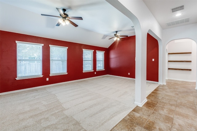 interior space featuring built in shelves, ceiling fan, and vaulted ceiling