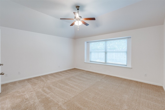 carpeted spare room featuring lofted ceiling and ceiling fan