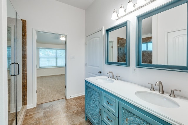 bathroom featuring ceiling fan, a shower with shower door, and vanity