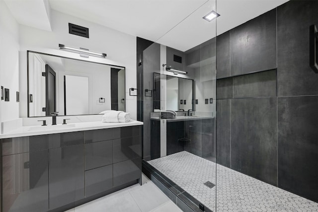 bathroom featuring a shower with door, vanity, and tile patterned flooring