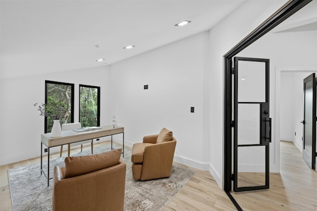 sitting room with lofted ceiling and light wood-type flooring