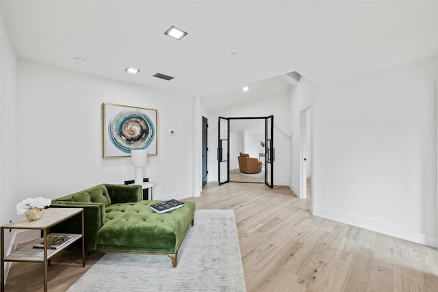 living room with lofted ceiling and light wood-type flooring