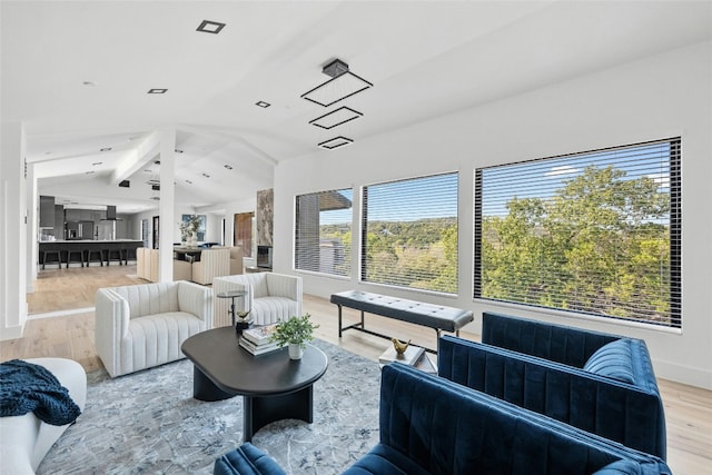 living room featuring light hardwood / wood-style flooring and lofted ceiling with beams