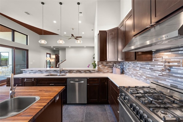 kitchen with wooden counters, decorative light fixtures, sink, decorative backsplash, and stainless steel appliances