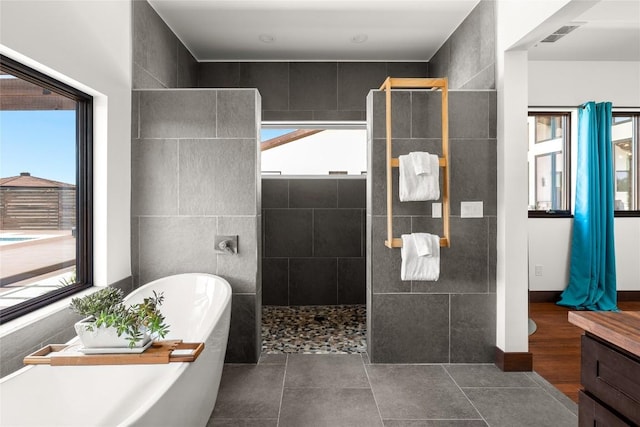 bathroom featuring tile patterned floors, vanity, and plus walk in shower