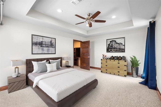 bedroom with carpet, ceiling fan, and a raised ceiling