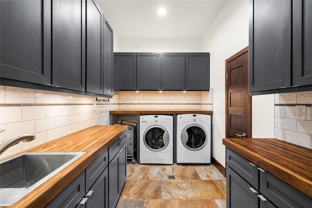 washroom featuring cabinets, sink, and washing machine and clothes dryer