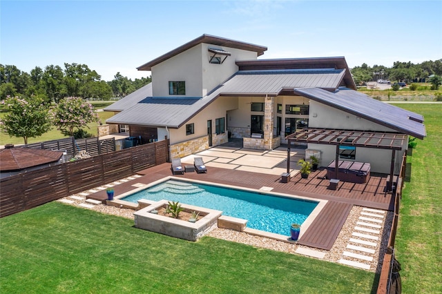 rear view of house with a fenced in pool, a patio area, and a lawn