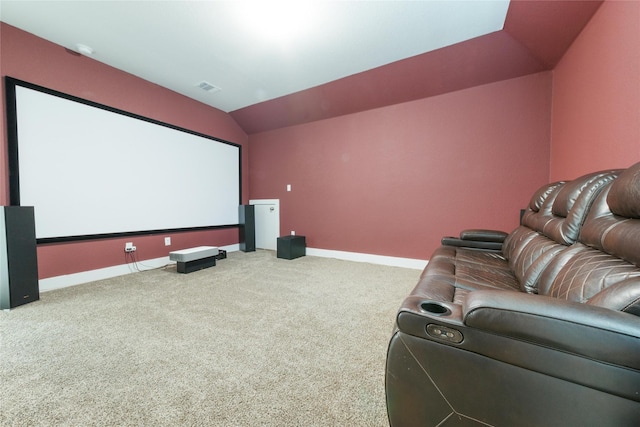 carpeted home theater room with vaulted ceiling