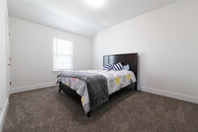 bedroom featuring dark carpet and vaulted ceiling