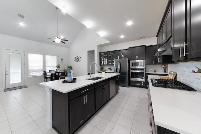 kitchen with a center island with sink, tasteful backsplash, appliances with stainless steel finishes, ceiling fan, and sink