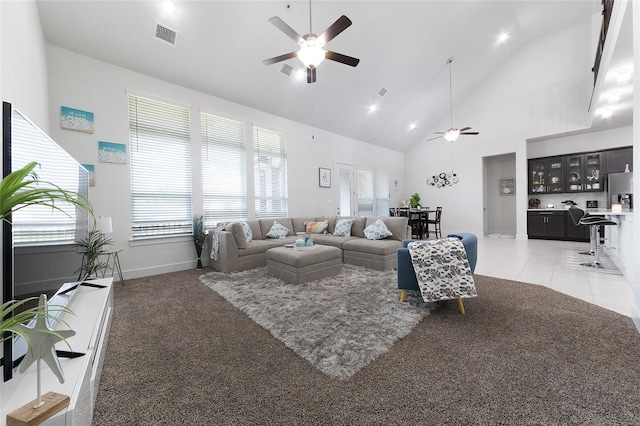 living room with a high ceiling, ceiling fan, and light colored carpet