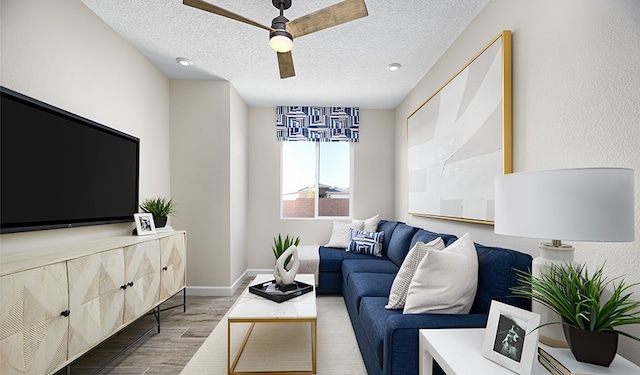 living room with ceiling fan, a textured ceiling, and light wood-type flooring