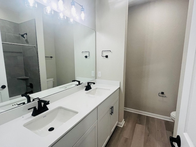 bathroom featuring toilet, a shower, vanity, and hardwood / wood-style floors