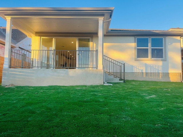 rear view of property featuring a yard