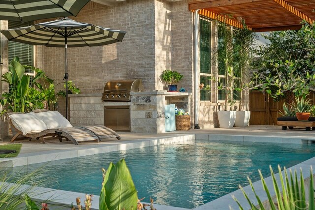 view of swimming pool with area for grilling, a grill, a patio, and a pergola