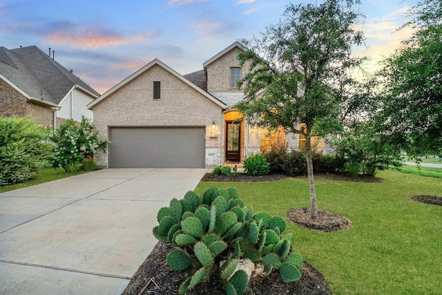 view of front of property featuring a garage and a lawn