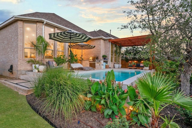 pool at dusk featuring a grill, area for grilling, and a pergola