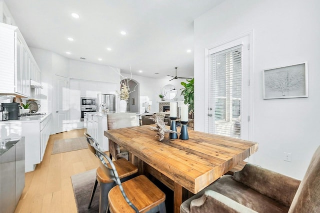 dining space with light hardwood / wood-style floors and ceiling fan