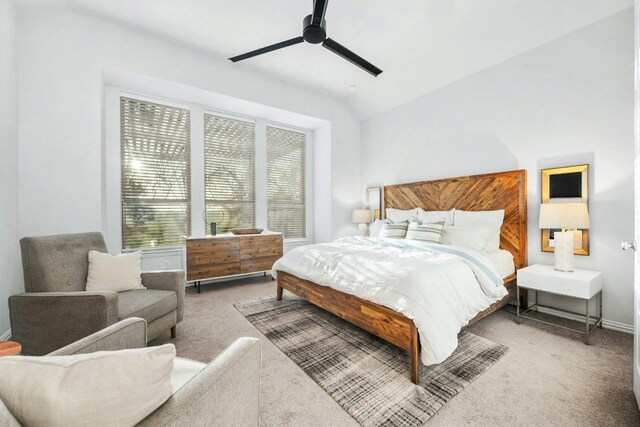 carpeted bedroom with ceiling fan and vaulted ceiling