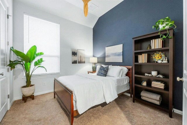 carpeted bedroom with ceiling fan and vaulted ceiling