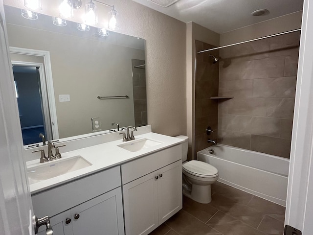 full bathroom featuring tile patterned floors, vanity, toilet, and tiled shower / bath