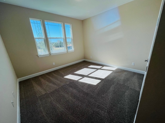 unfurnished room featuring dark colored carpet