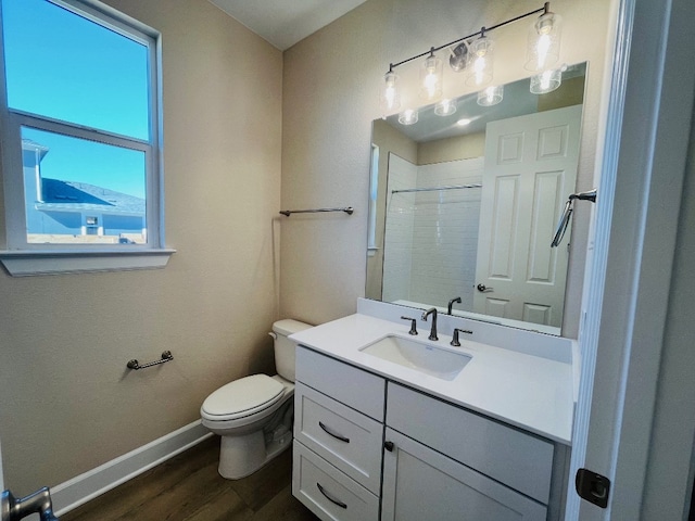 bathroom featuring a shower, hardwood / wood-style floors, vanity, and toilet