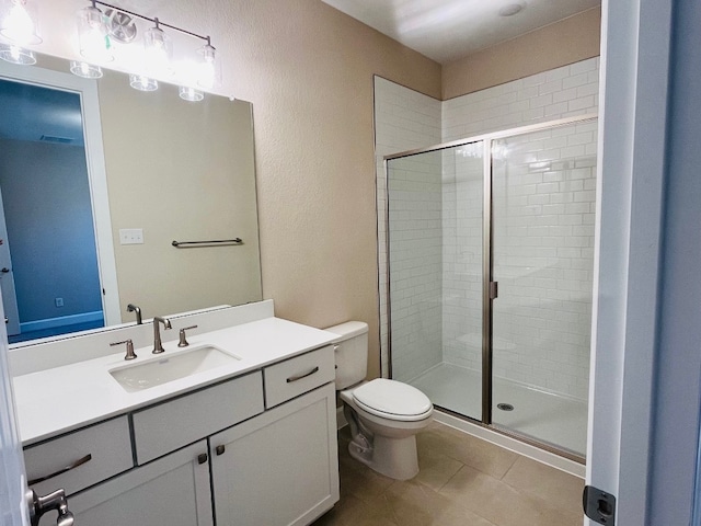 bathroom featuring tile patterned floors, vanity, toilet, and walk in shower