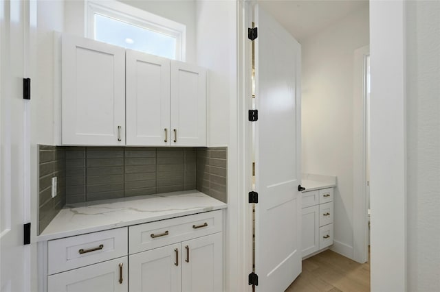 interior space featuring light wood-type flooring and tasteful backsplash