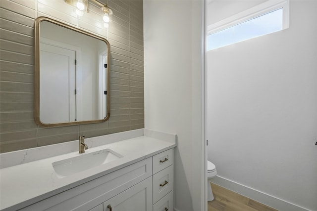 bathroom featuring tile walls, wood-type flooring, toilet, and vanity