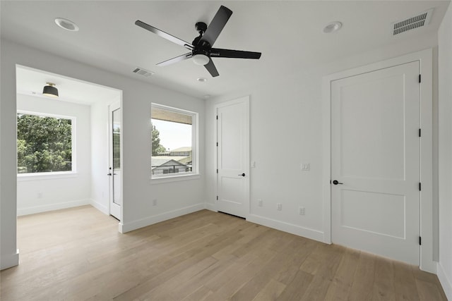 unfurnished room with light wood-style floors, baseboards, visible vents, and recessed lighting