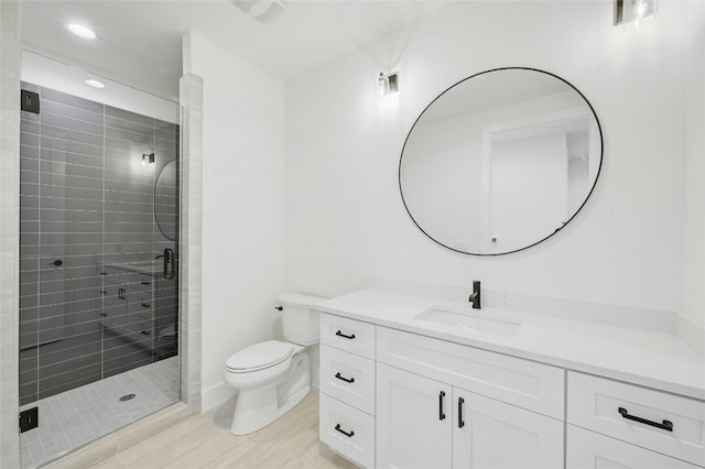 bathroom featuring a stall shower, vanity, toilet, and recessed lighting