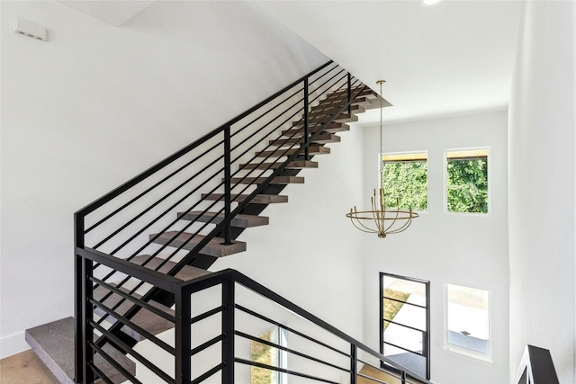 staircase with an inviting chandelier and hardwood / wood-style floors