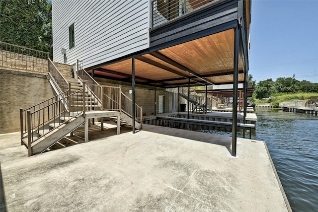 view of patio / terrace featuring a dock, a water view, and stairway