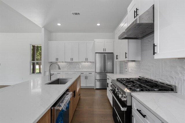 kitchen with tasteful backsplash, light stone counters, dark hardwood / wood-style floors, stainless steel appliances, and sink