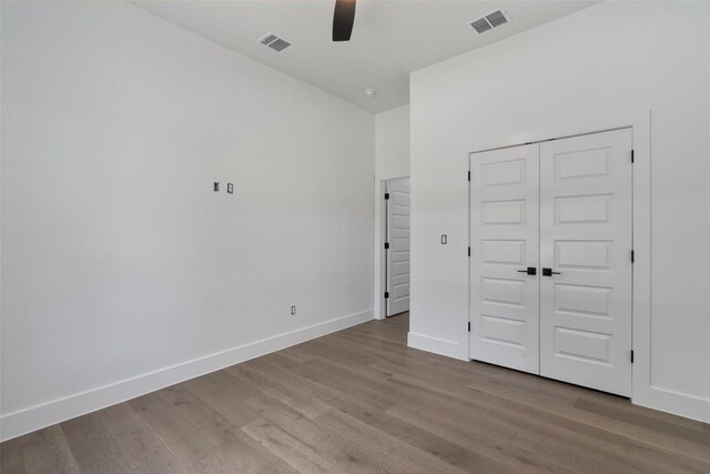 unfurnished bedroom featuring ceiling fan, hardwood / wood-style flooring, and a closet