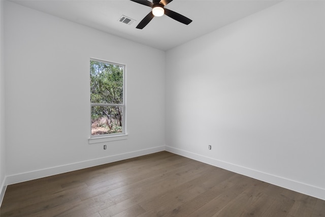 empty room featuring a healthy amount of sunlight, dark hardwood / wood-style flooring, and ceiling fan