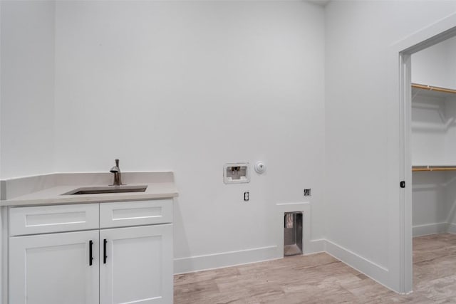 laundry area with gas dryer hookup, sink, cabinets, light hardwood / wood-style flooring, and hookup for a washing machine