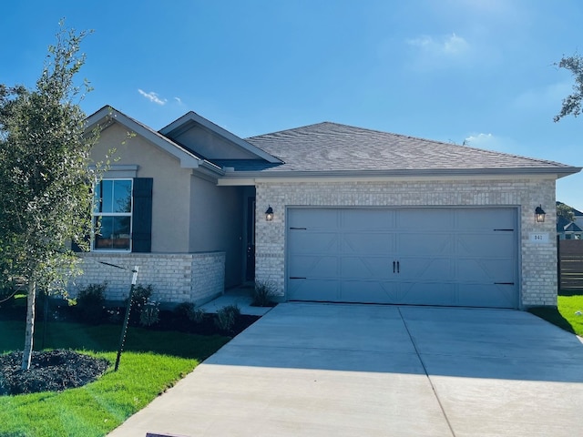 ranch-style house with a garage and a front lawn