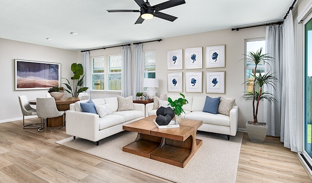 living room with light hardwood / wood-style floors and ceiling fan