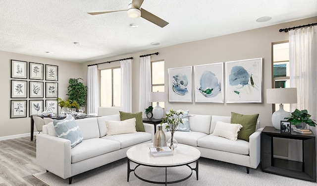 living room with a textured ceiling, light hardwood / wood-style floors, and ceiling fan