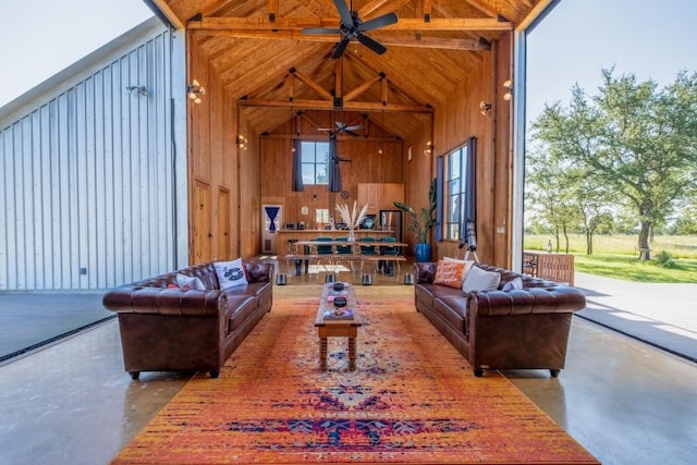 living room with concrete flooring, beamed ceiling, high vaulted ceiling, and wooden walls