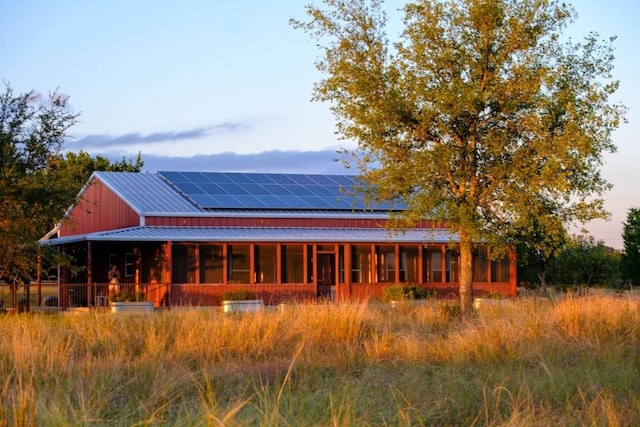 back house at dusk featuring solar panels