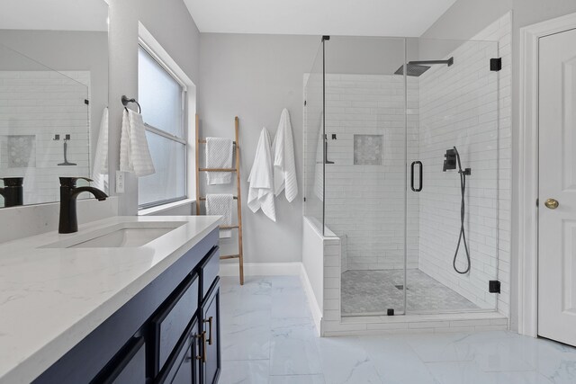 bathroom with vanity, a shower with shower door, and a healthy amount of sunlight