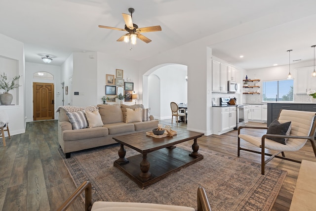 living room featuring ceiling fan and dark hardwood / wood-style floors