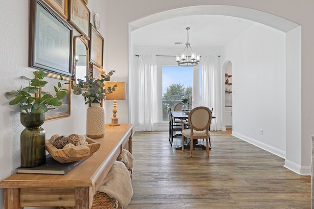 dining room with an inviting chandelier and dark wood-type flooring