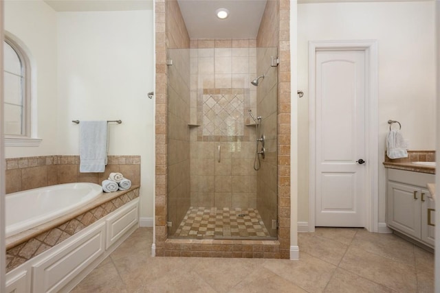 bathroom featuring tile patterned floors, plus walk in shower, and vanity