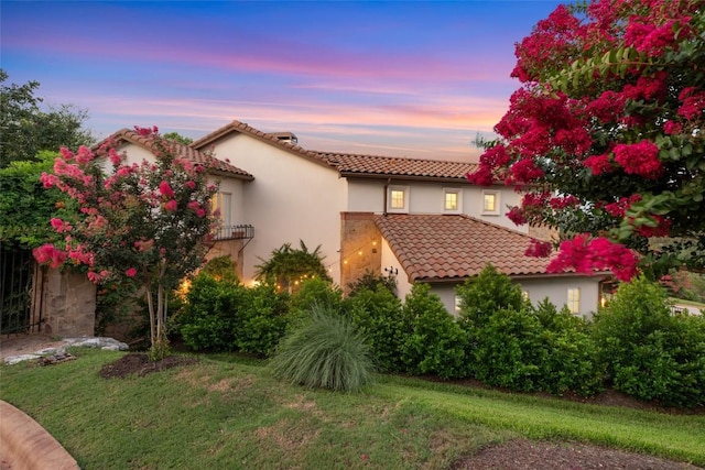 mediterranean / spanish home with a lawn